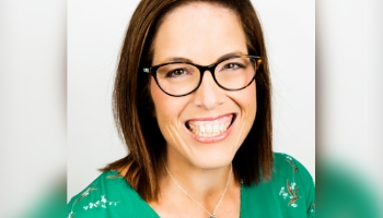 Patient Advocate Kris, a smiling woman with shoulder-length brown hair and glasses in bright green sweater, part of an active multigenerational PI family
